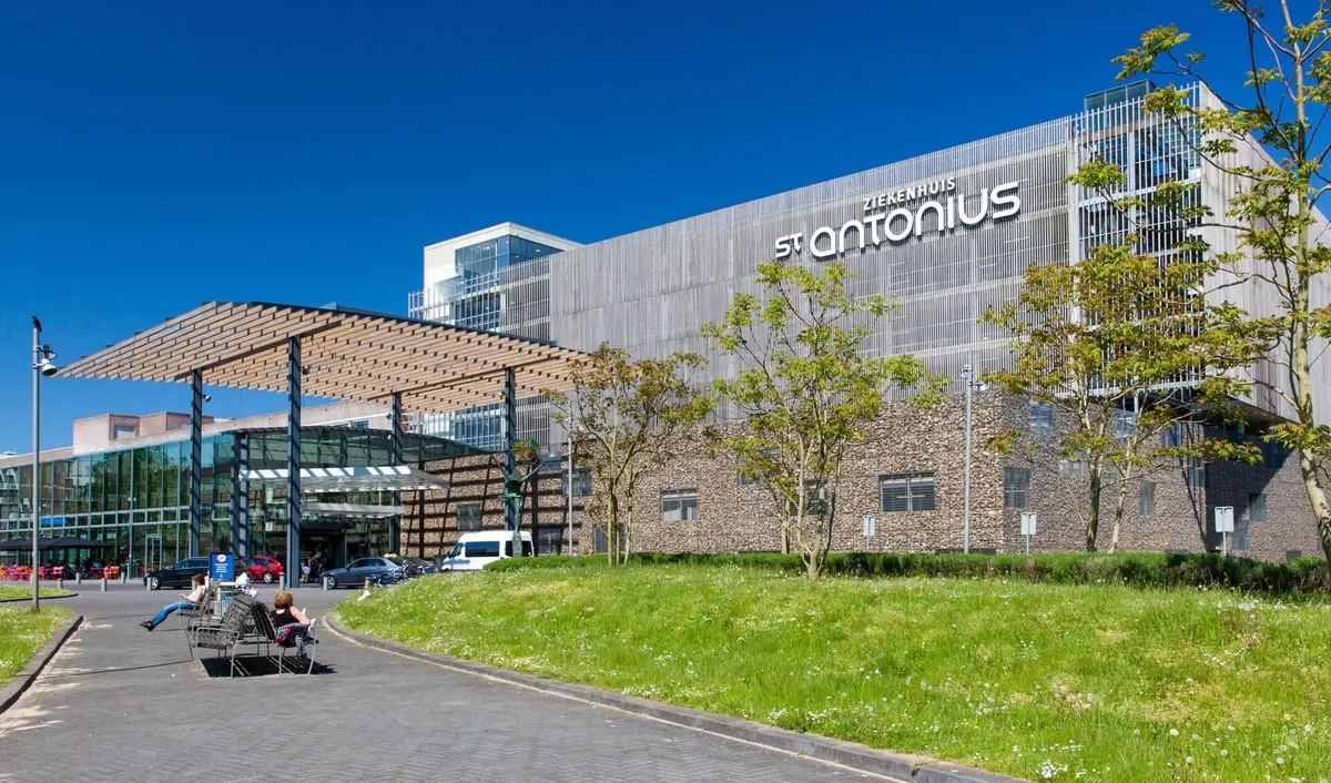 Het gebouw van het St. Antonius Ziekenhuis met de entree en een grasveld ervoor.