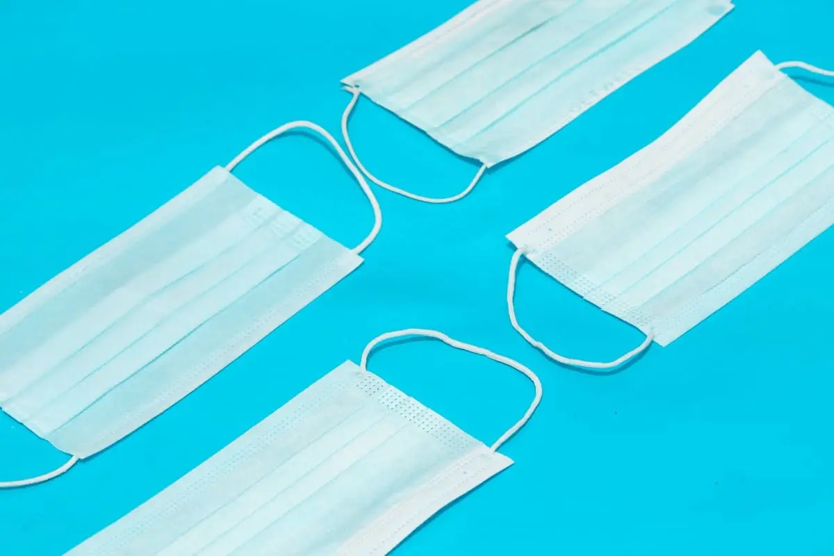 Três máscaras de proteção sobre um fundo azul.