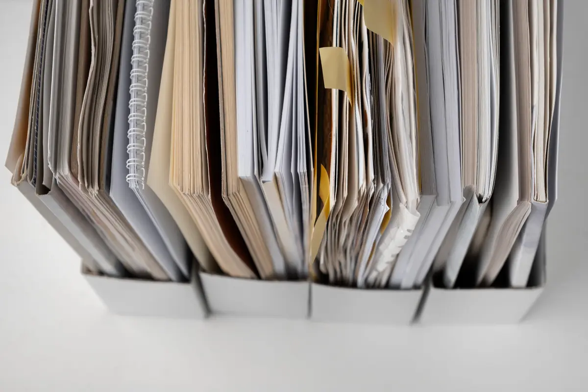 Uma fila de pastas de arquivo cheias de documentos.