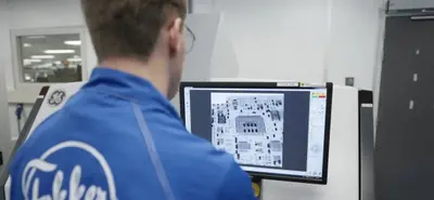 Um funcionário da Fokker consulta um desenho técnico num ecrã.