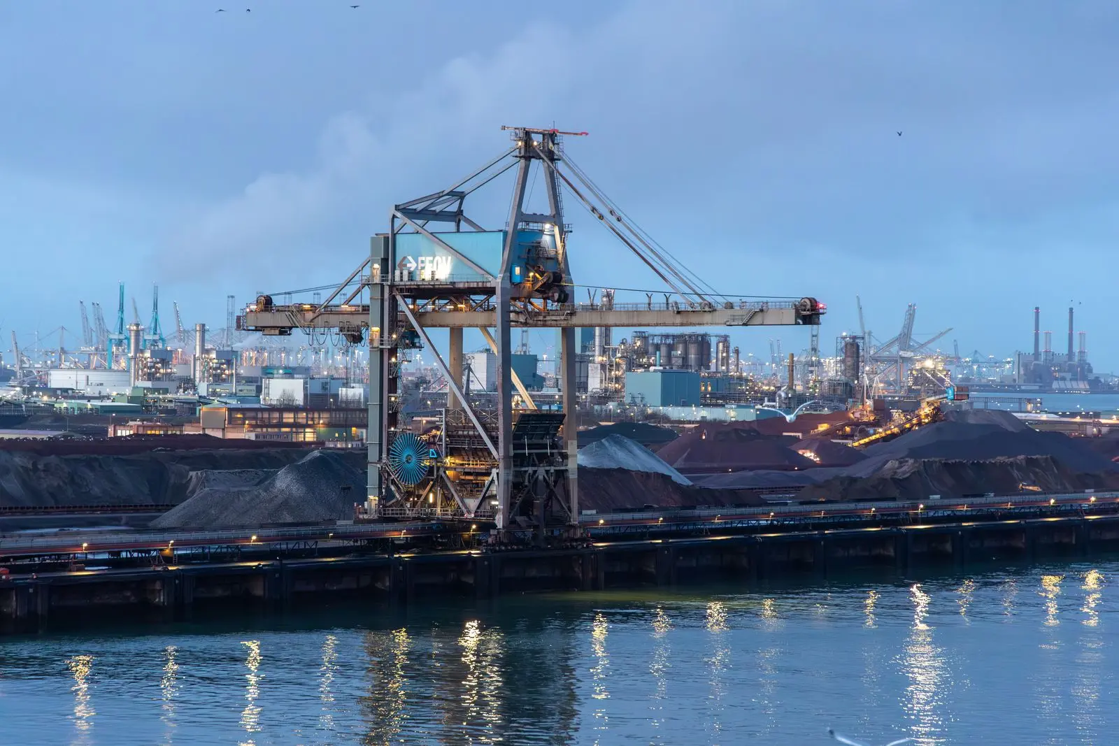 Kraan aan de kade in de Rotterdamse Europoort bij schemering