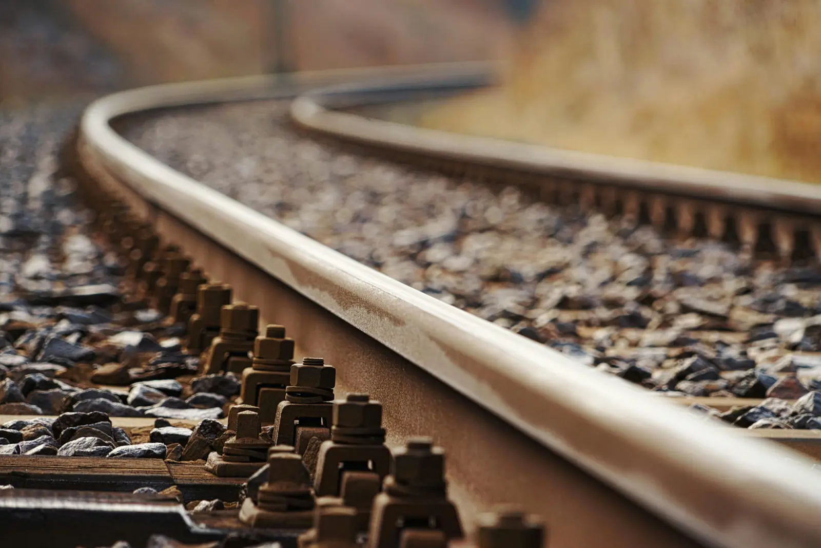 Grande plano de um carril ferroviário numa curva.