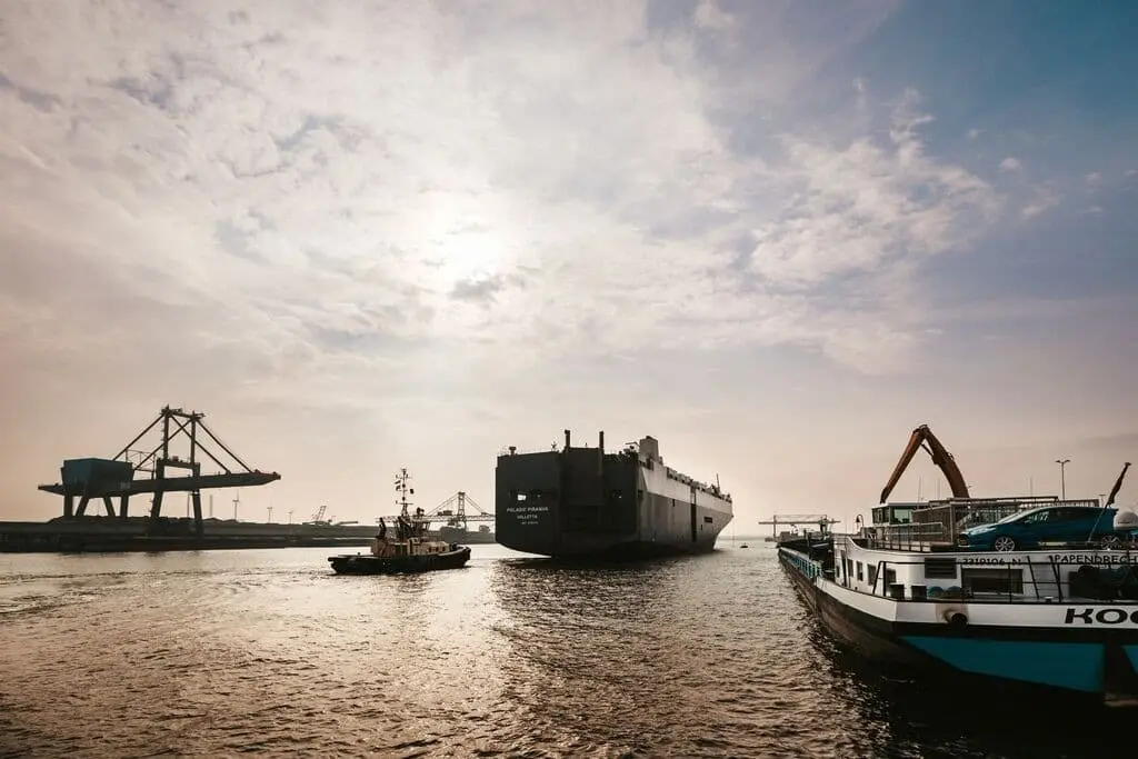 Ships in a harbour with the sun low in the sky.