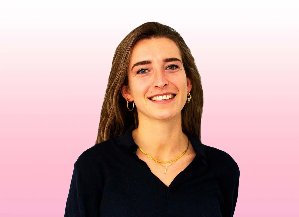 Retrato de uma mulher sorridente sobre um fundo cor-de-rosa.